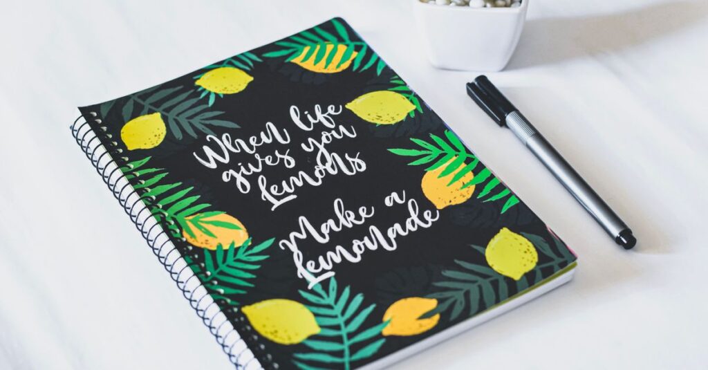 Spiral notebook with a motivational lemon-themed cover and a pen, perfect for journaling or note-taking.