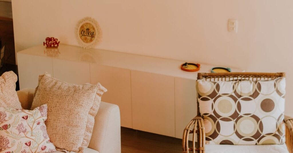 Warm and inviting living room with modern art, rattan chair, and sofa.