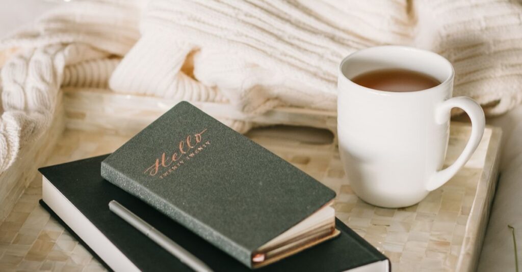 Relaxing setup with a cup of tea and journal on a bed, perfect for a cozy winter afternoon.