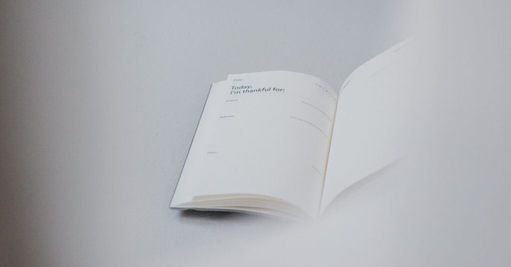 From above of opened notebook with empty pages placed on white working table
