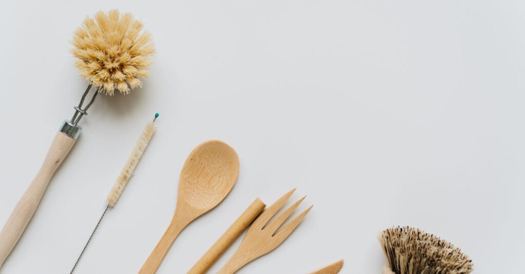 Flat lay of wooden kitchen utensils and brushes promoting eco-friendly lifestyle and sustainability.