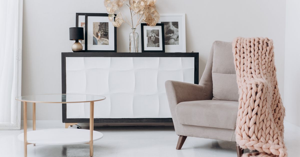 A cozy, contemporary interior setup with a beige chair, soft decor, and elegant furnishings.