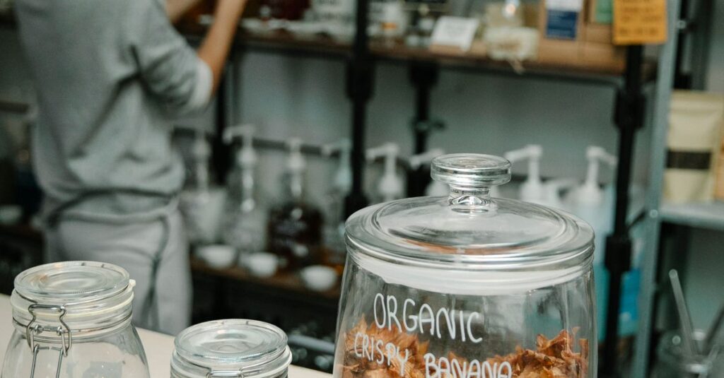 Crop anonymous female near shelves and table with glass jars filled with organic food