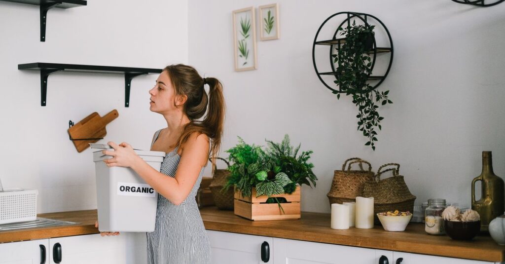 A woman sorting organic waste in a stylish kitchen promoting eco-friendly living.