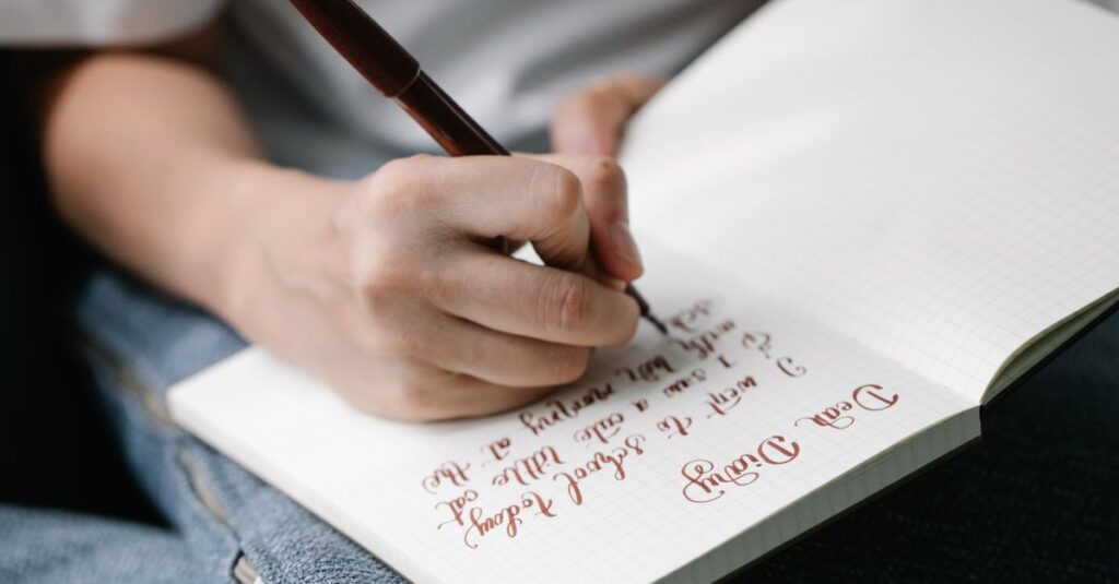 Person writing in a notebook with elegant handwritten calligraphy.
