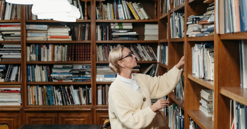 Woman exploring a library bookshelf with a thoughtful expression, surrounded by books.
